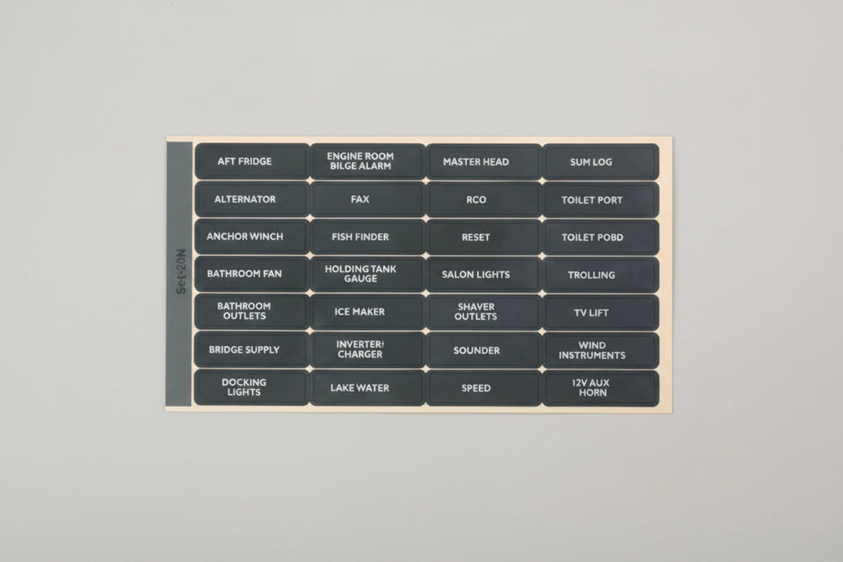 A dark gray rectangular panel with multiple rows and columns of small white text labels, photographed against a plain white background.